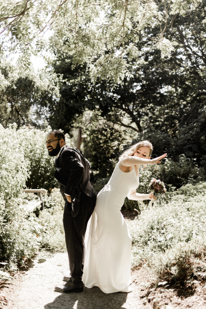 bride and groom touching butts together at this Victoria wedding in finnerty gardens