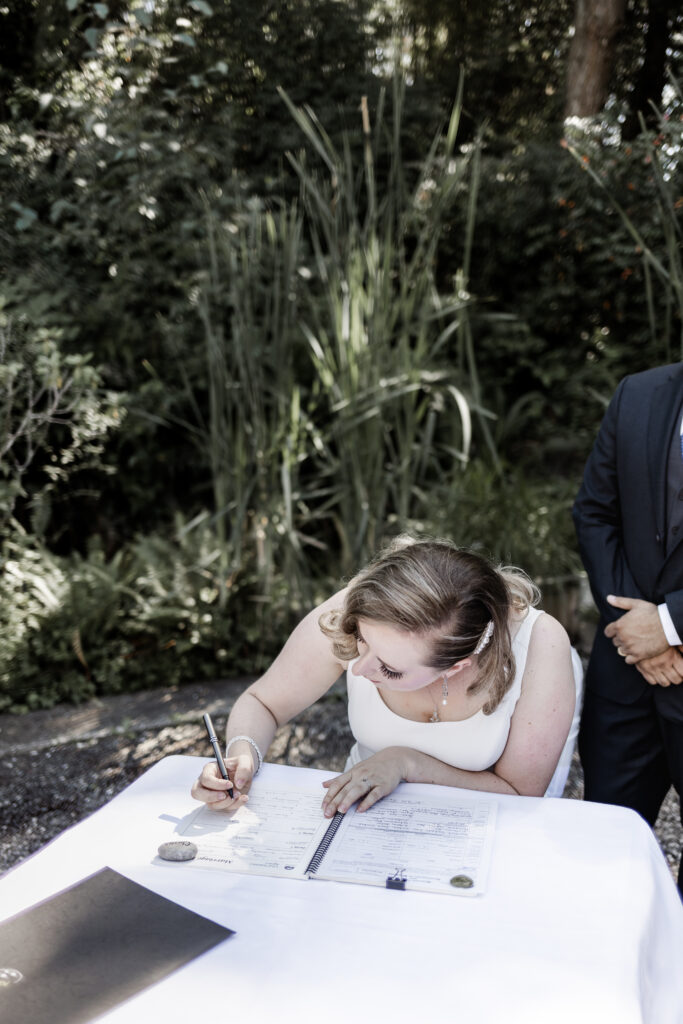 bride signing wedding papers at this Victoria wedding