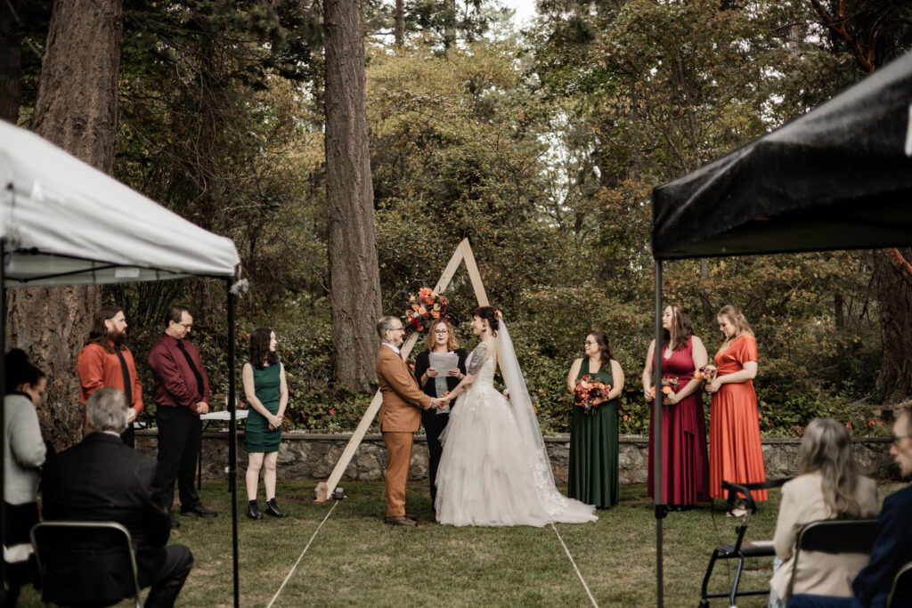 bride and groom hold hands at the altar at this punk wedding in Victoria, BC