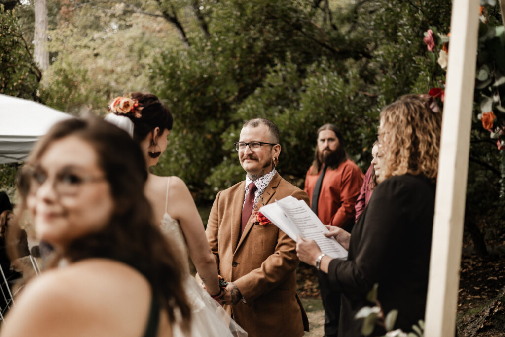 groom smiles at his bride at the altar at this punk wedding in Victoria, BC