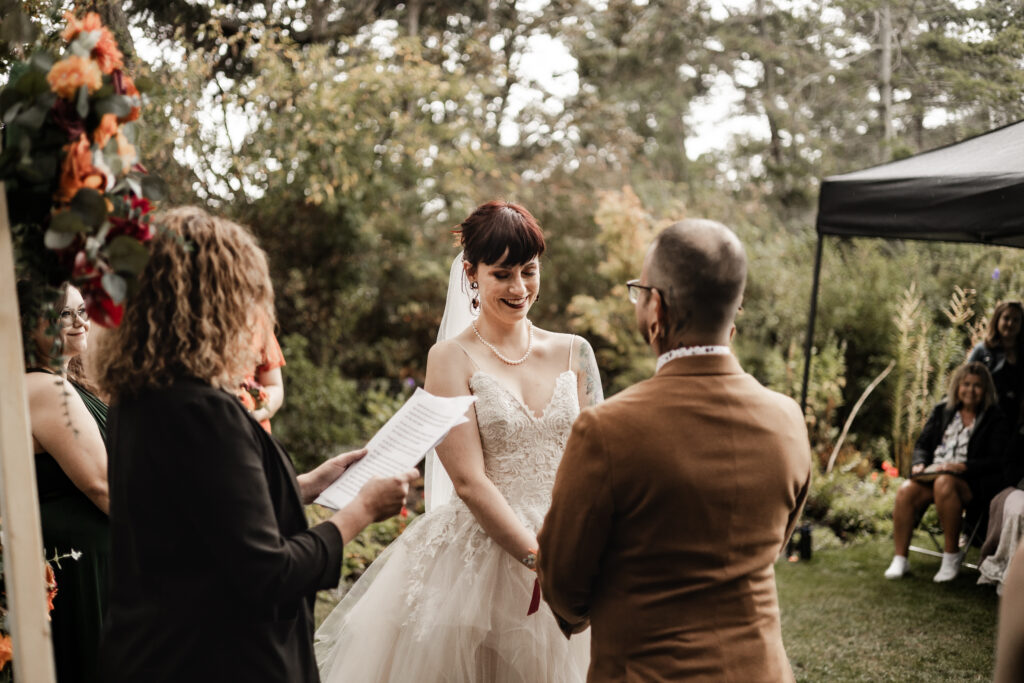 bride smiles at groom during the ceremony at this punk wedding in Victoria, BC