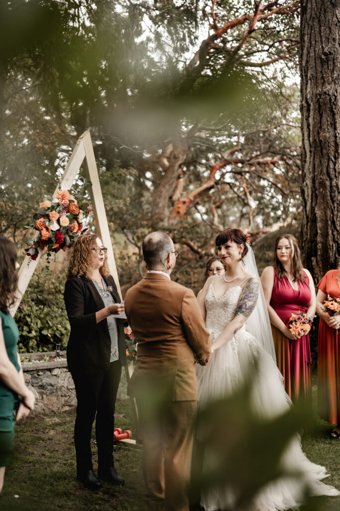 bride and groom hold hands at the altar at this punk wedding in Victoria, BC