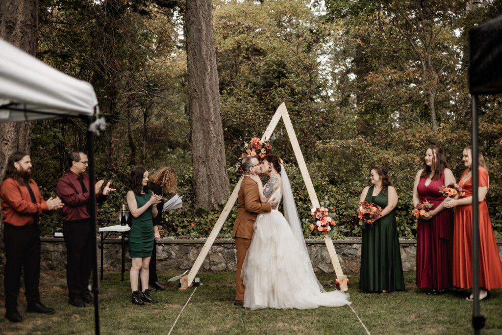 bride and groom have their first kiss at the altar at this punk wedding in Victoria, BC