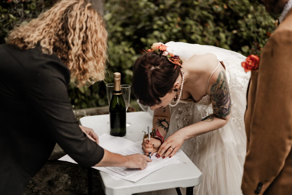 bride signs marriage license at this punk wedding in Victoria, BC