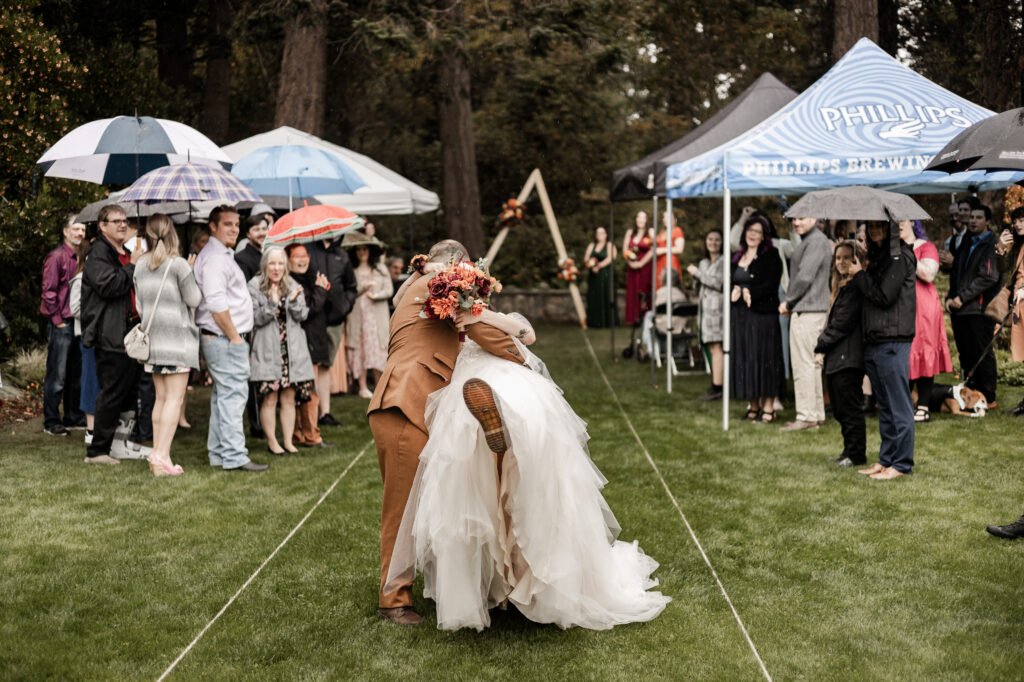 bride and groom do a kiss and dip at the end of the aisle at this punk wedding in Victoria, BC