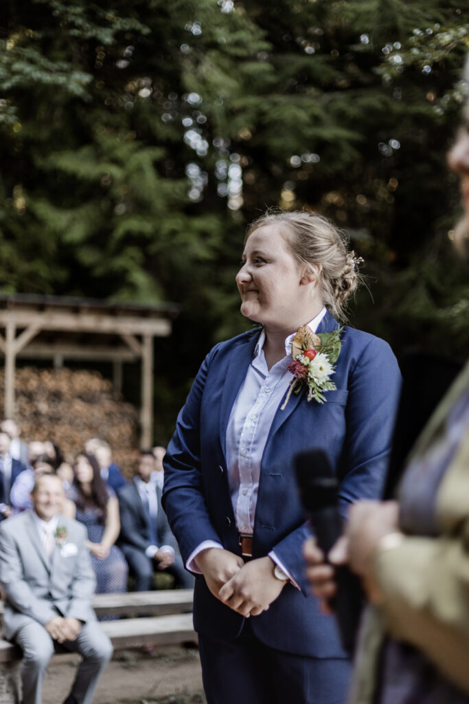 Morgan admires Kirsten walking down the aisle at this Camp Elphinstone wedding.