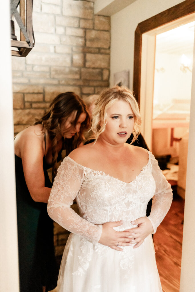 Bride gets her dress done up at this cabin elopement