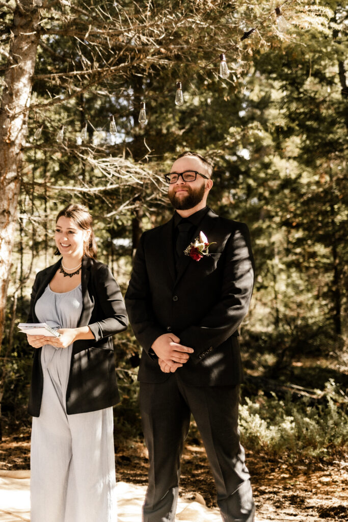 Groom watches bride walk down the aisle at this cabin elopement