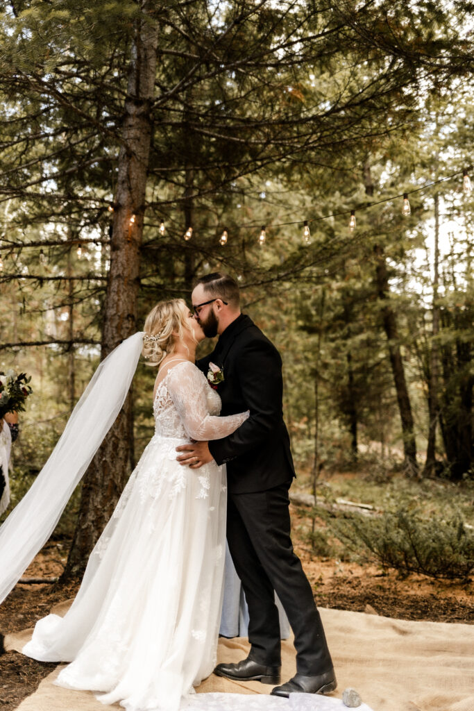 Bride and groom have their first kiss at this cabin elopement