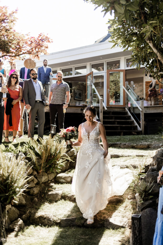 The bride walks down the aisle at this garden party wedding.