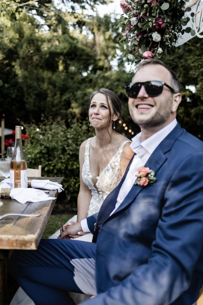 The bride holds back tears during speeches at this garden party wedding