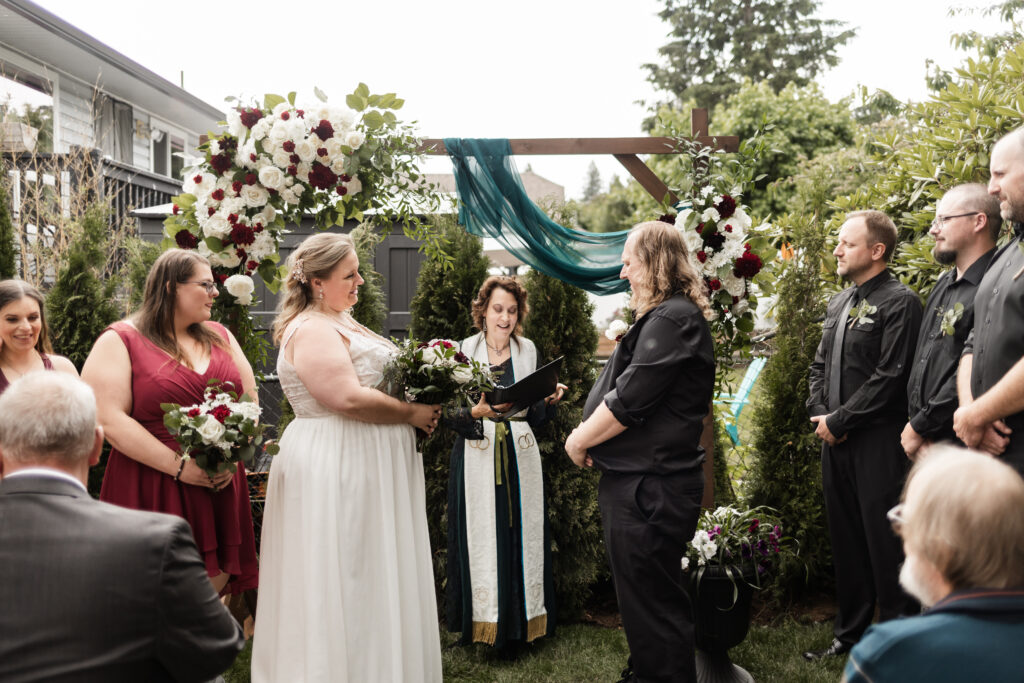 Bride and groom stand at the altar at their backyard wedding in Mission