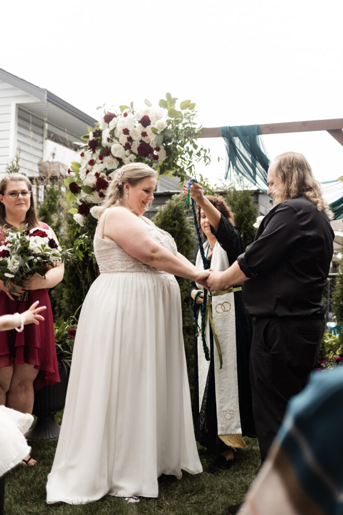 Bride and groom have a hand fasting ceremony at their backyard wedding in Mission