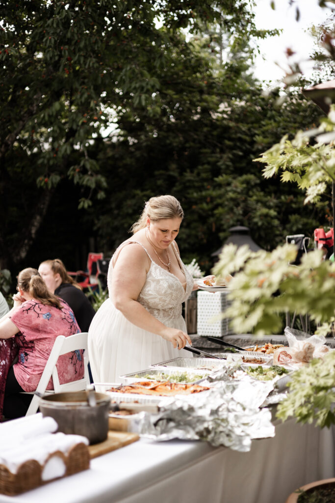 Bride gets food at her backyard wedding in Mission