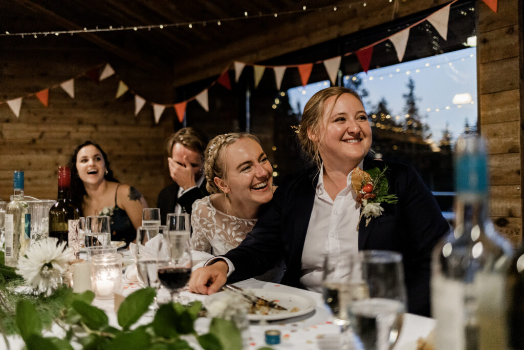 The couple share a laugh during speeches at this Camp Elphinstone wedding.