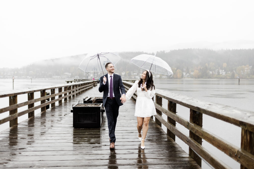 Bride and groom hold hands on the dock at rocky point park