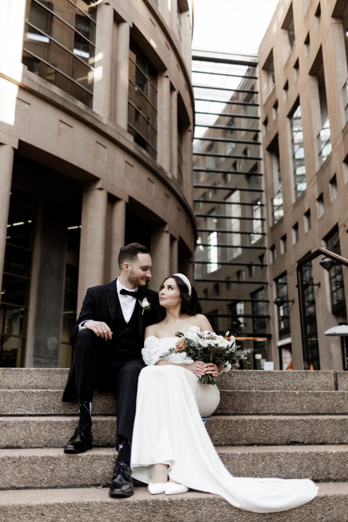 Bride and groom pose in front of the Vancouver public library at this downtown Vancouver wedding