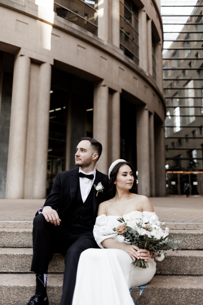 Bride and groom pose in front of the Vancouver public library at this downtown Vancouver wedding