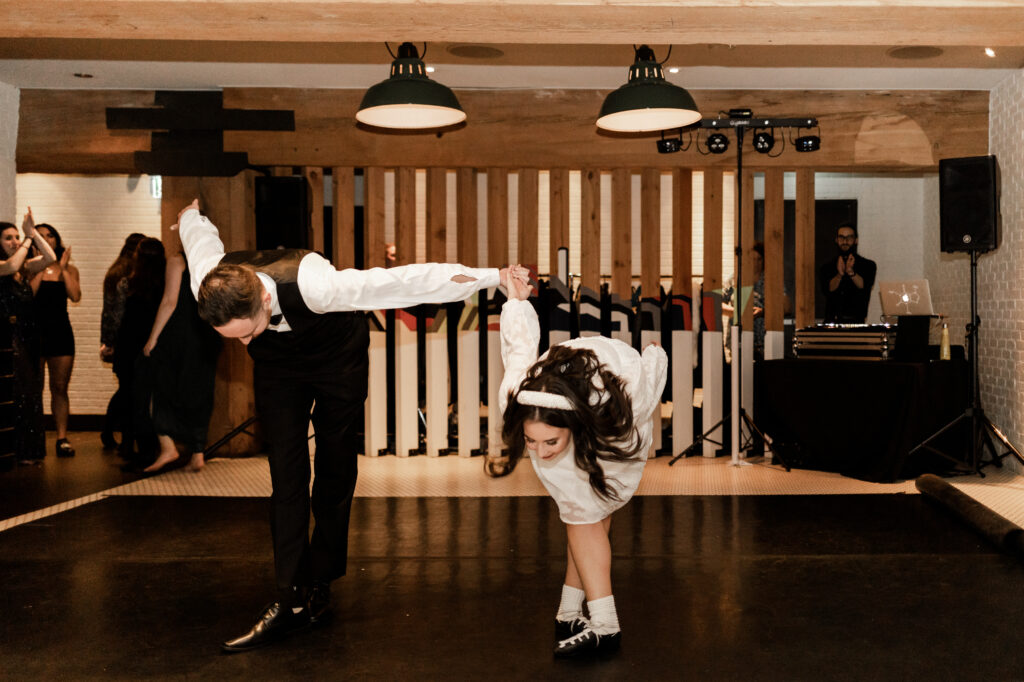 bride and groom bow for their guests after they Irish dance at Loft at Earls at this downtown Vancouver wedding