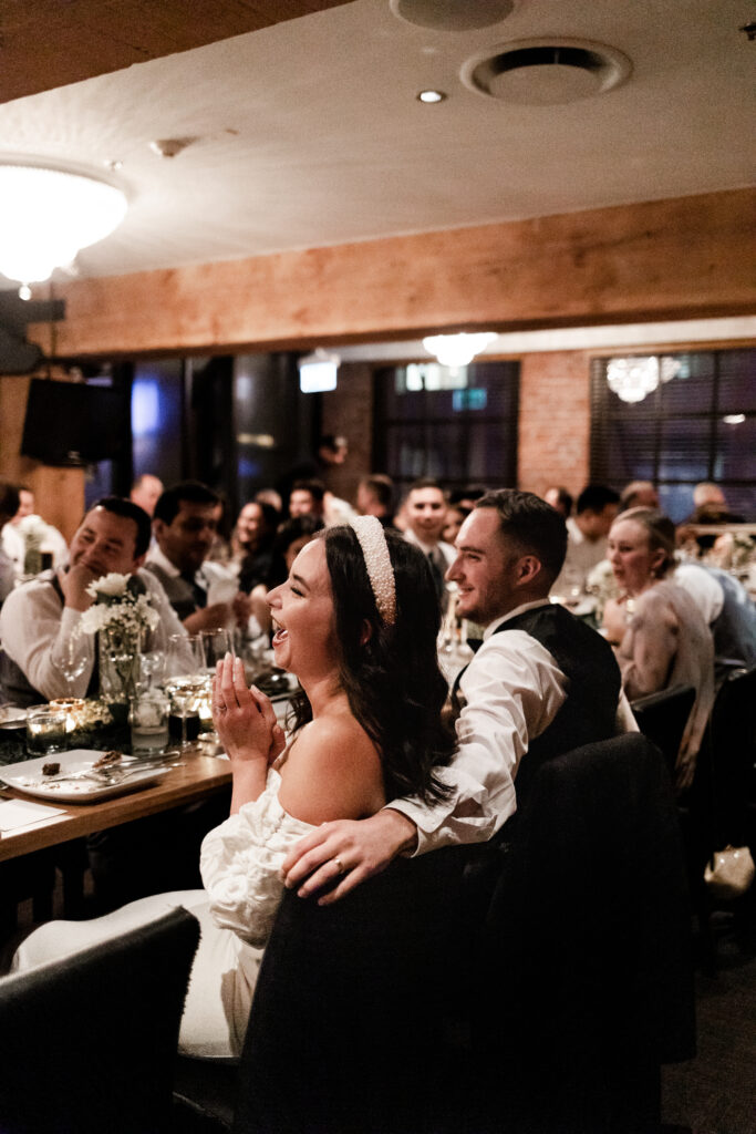 Bride and groom laugh during speeches at the Loft at Earls at this downtown Vancouver wedding