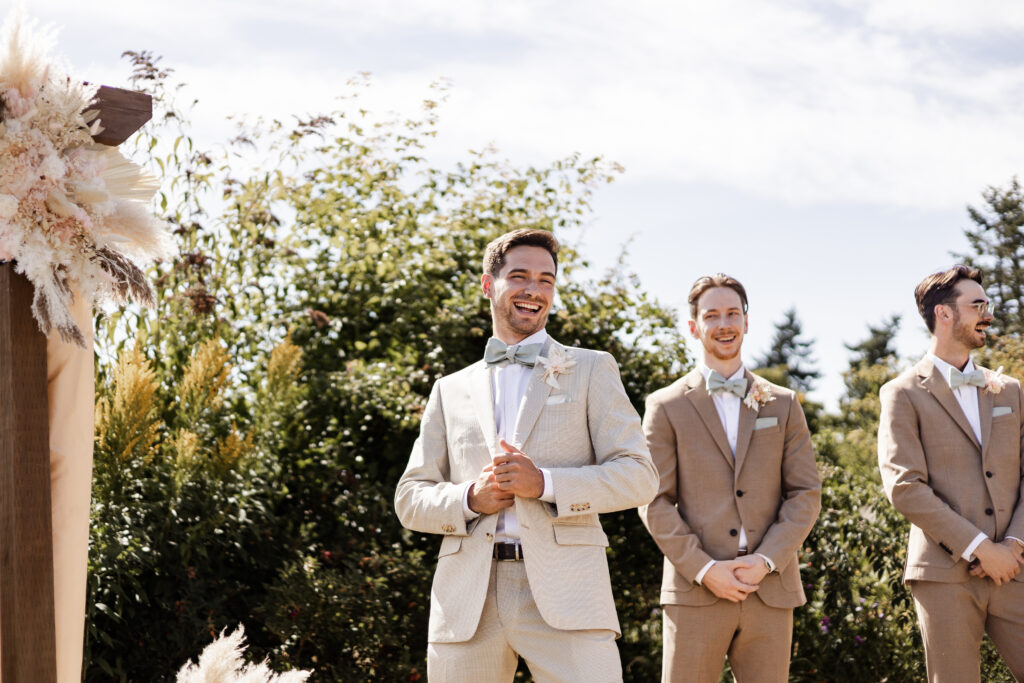 The groom smiles as he sees his bride walking towards him down the aisle at this Kildara Farms Wedding