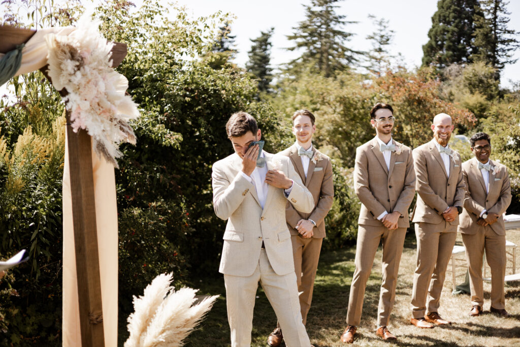 The groom wipes a tear away as his bride approaches at this Kildara Farms wedding