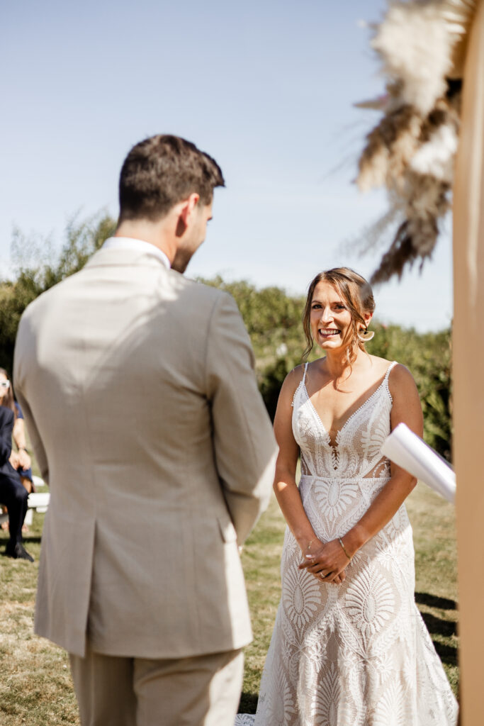 The bride smiles at the groom at the altar at this Kildara Farms wedding