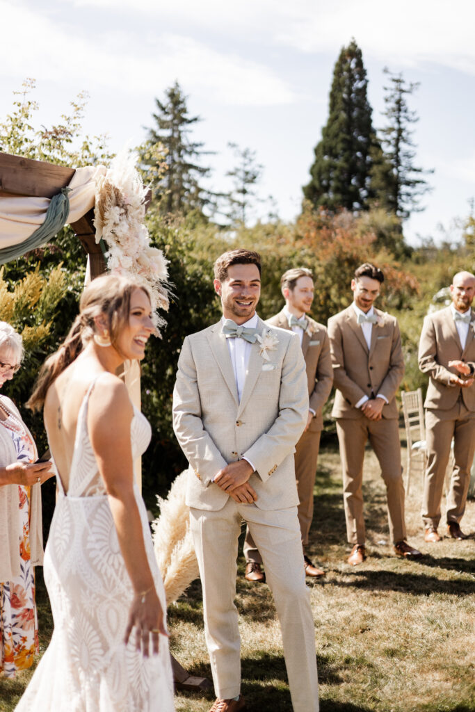 The bride and groom smile at they look at their guests during the ceremony at this Kildara Farms wedding