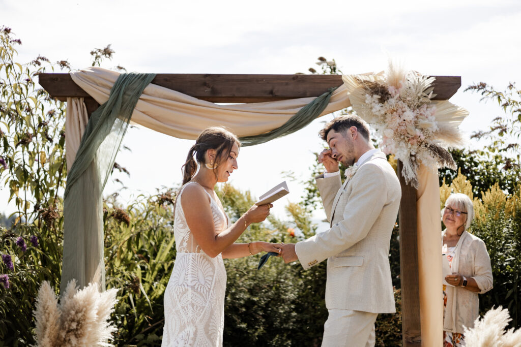 The groom wipes a tear away as his bride reads her vows at their Kildara Farms wedding