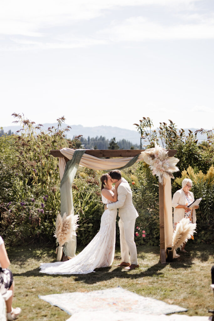 The bride and groom share a first kiss at the altar at their Kildara Farms wedding