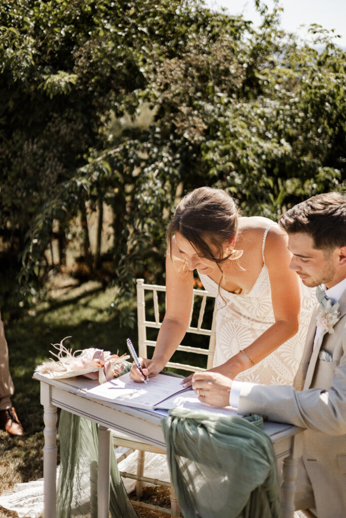 The brides leans over to sign the marriage papers at this Kildara Farms wedding