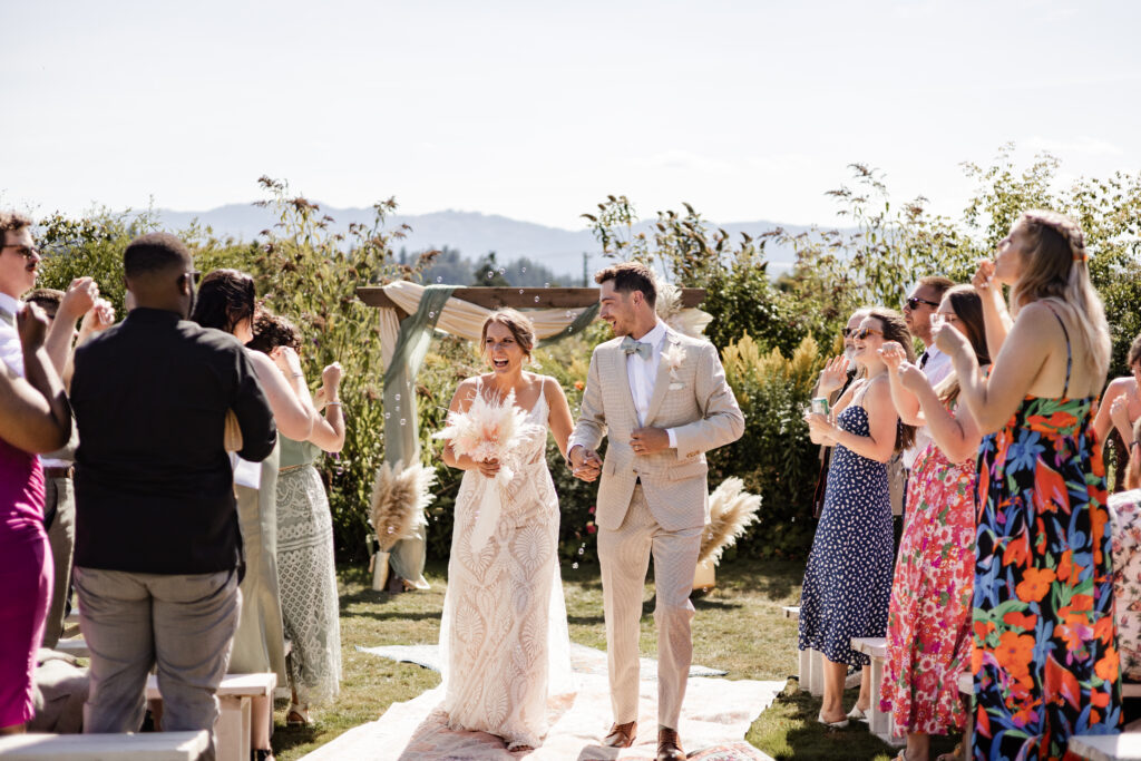 The bride and groom smile as they walk back down the aisle together at this Kildara Farms wedding