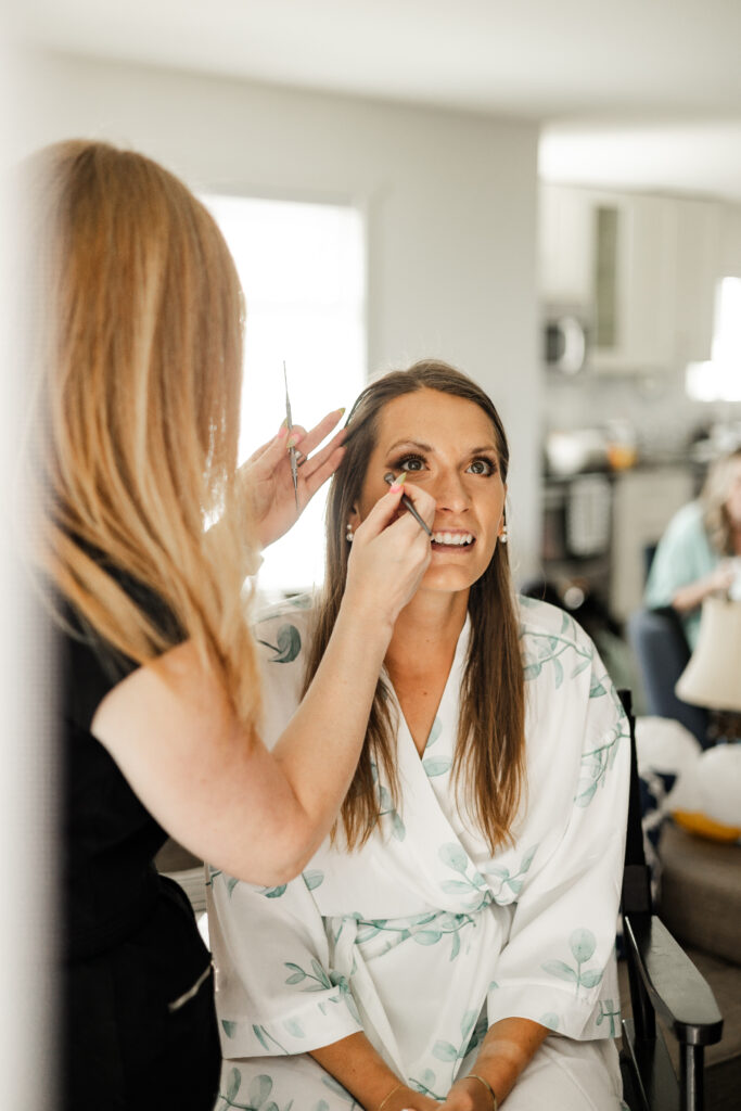 Bride smiles as she gets her makeup done for her Kildara Farms wedding