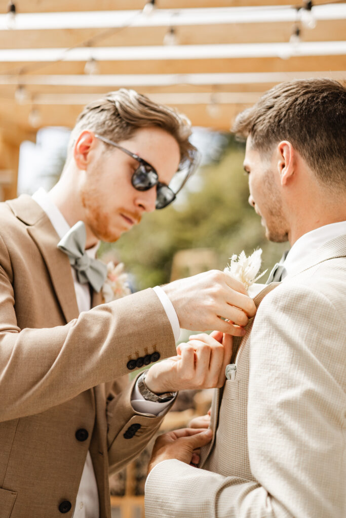 The groom gets his boutonniere pinned on by his best man at this Kildara Farms wedding