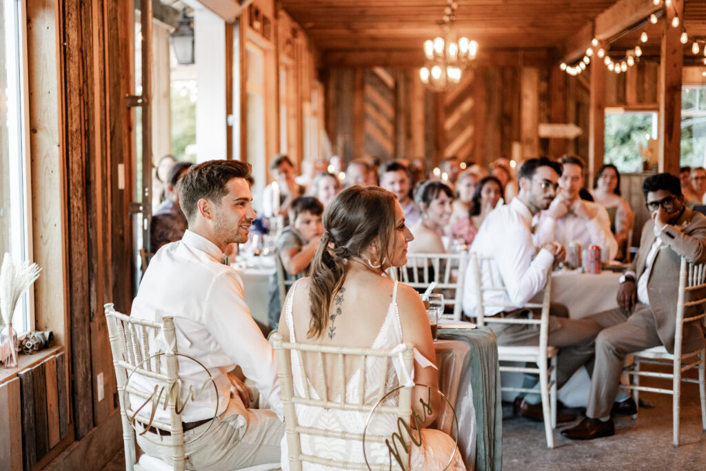 The newly weds listen to speeches at their Kildara Farms wedding