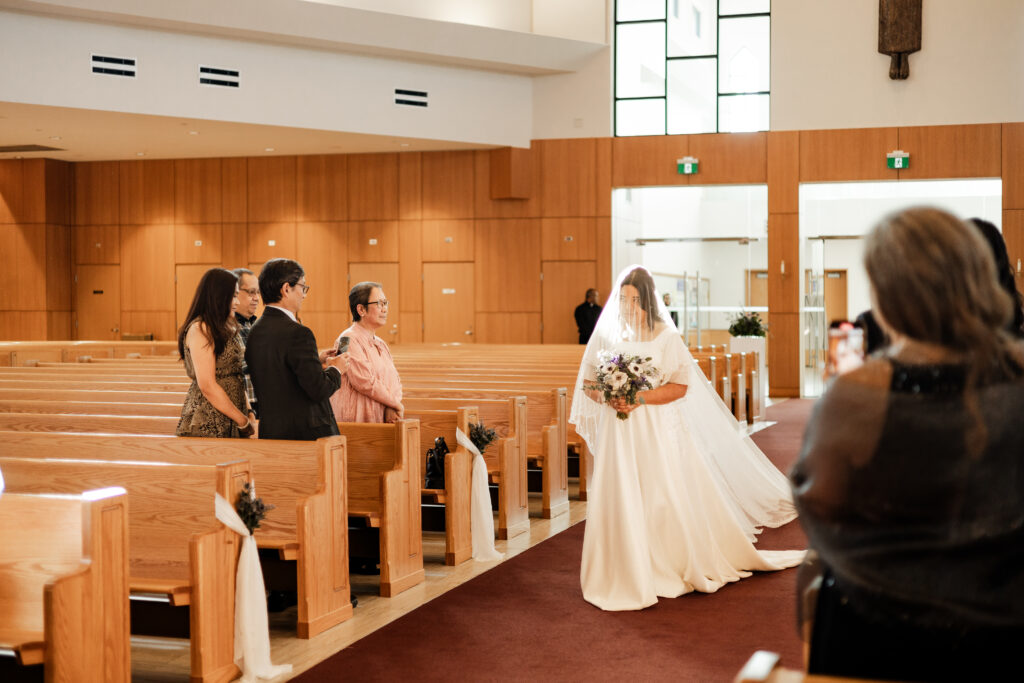 Bride enters the St. Paul's Parish ceremony at her wedding at Seasons Restaurant