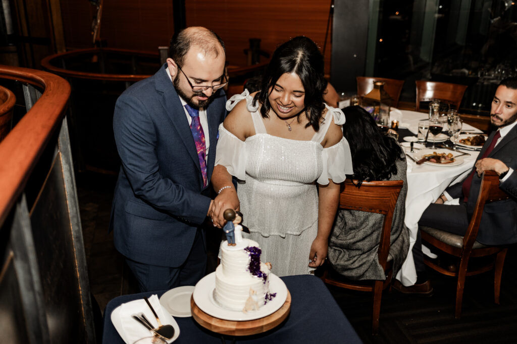 Bride and groom cut their cake at their wedding at seasons restaurant