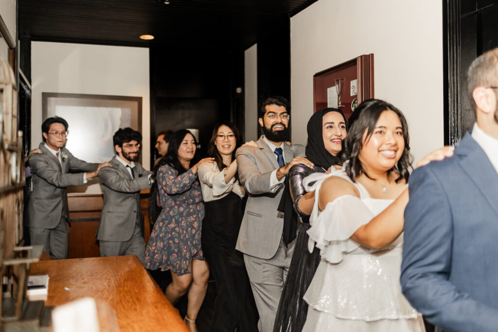 Guests form a congo line to the dance floor at this wedding at seasons restaurant