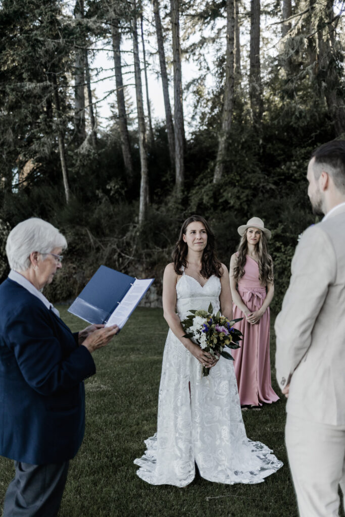 The bride gazes into the grooms eyes as the officiant marries them at their east sooke elopement.