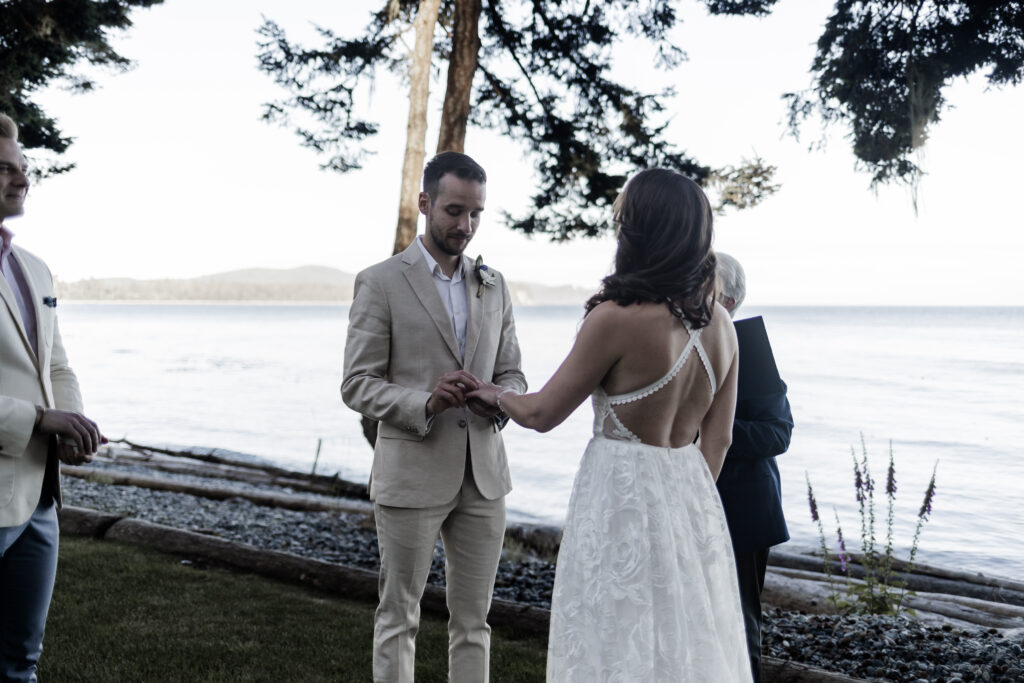 The couple exchanges rings during the ceremony at their east sooke elopement.