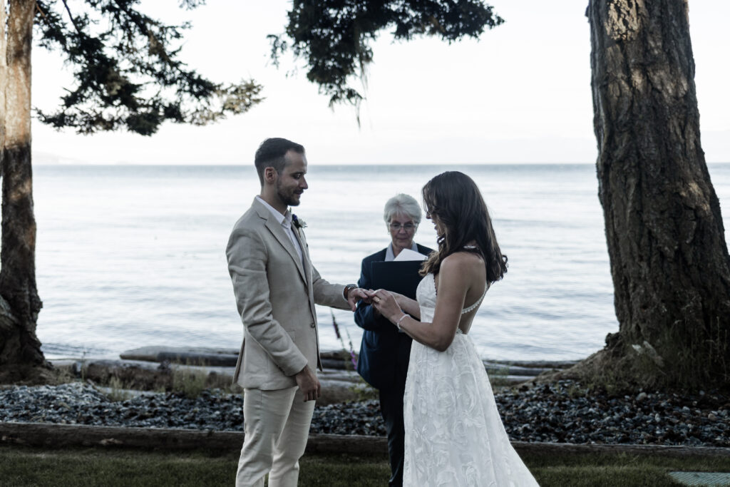 The couple exchanges rings during the ceremony at their east sooke elopement.