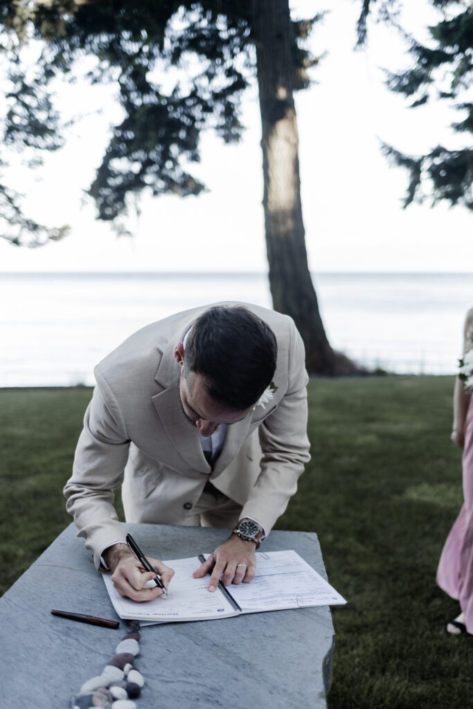 The groom signs the marriage papers at his east sooke elopement.