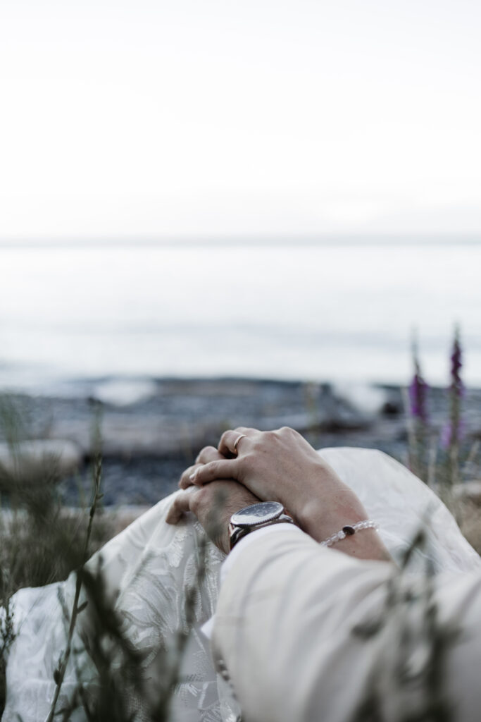 An upclose of the bride and groom holding hands, showing off the bride's new wedding ring at their east sooke elopement.