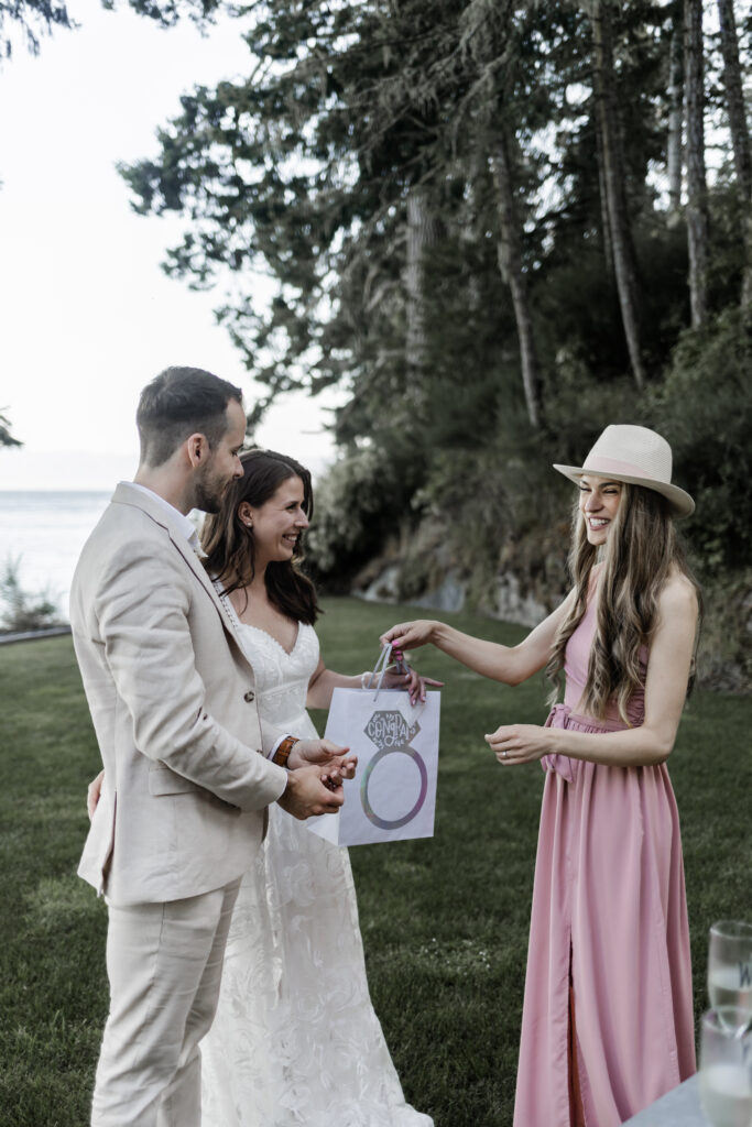 The newly weds are handed a gift from their friend at their east sooke elopement.