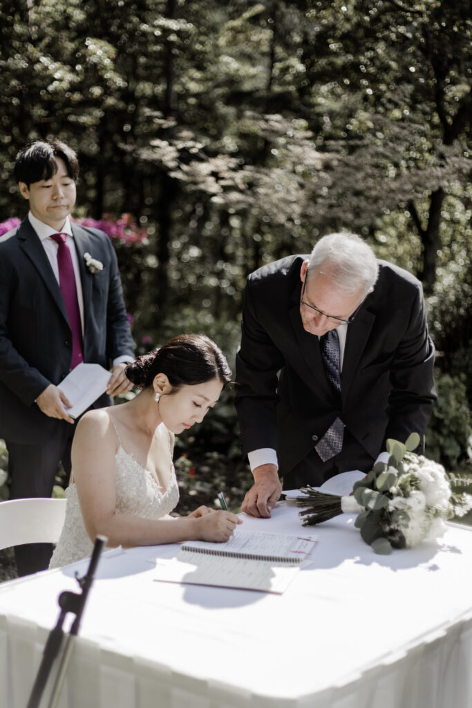 bride signs wedding papers at this Olympic View Golf Club wedding