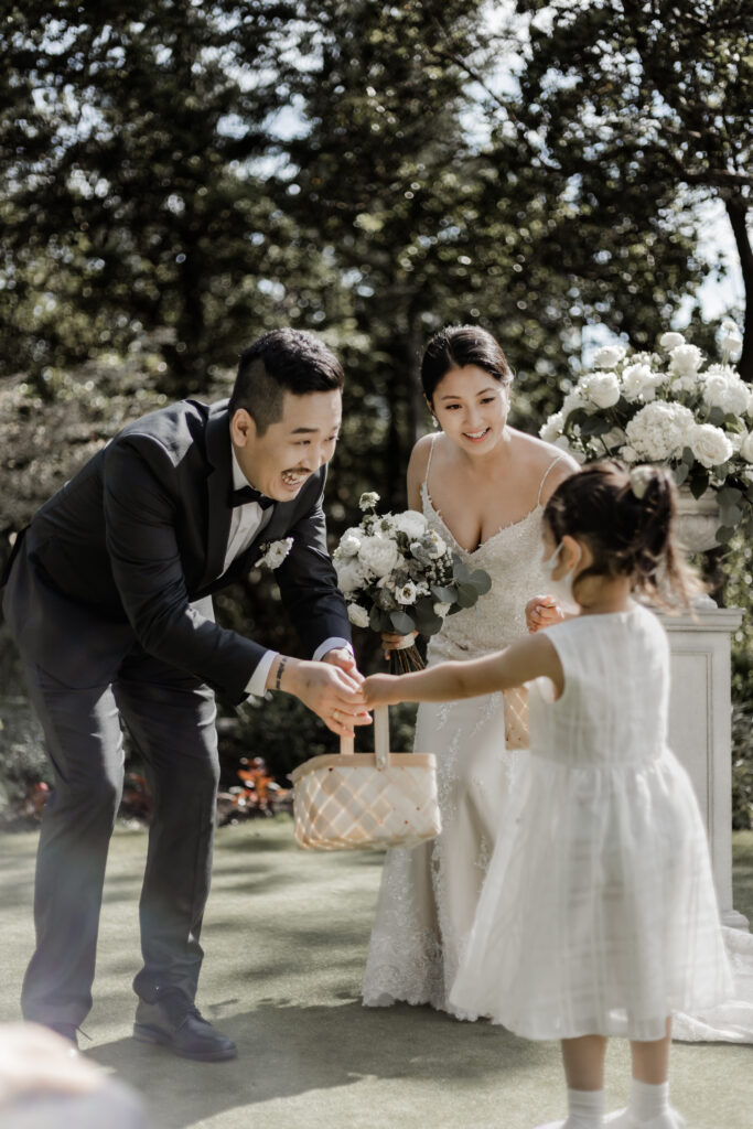 flower girl greets bride and groom at the end of the aisle at this Olympic View Golf Club wedding