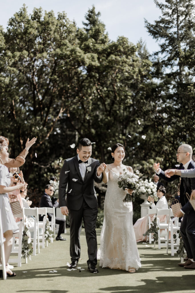 bride and groom smile as they walk back down the aisle at this Olympic View Golf Club wedding