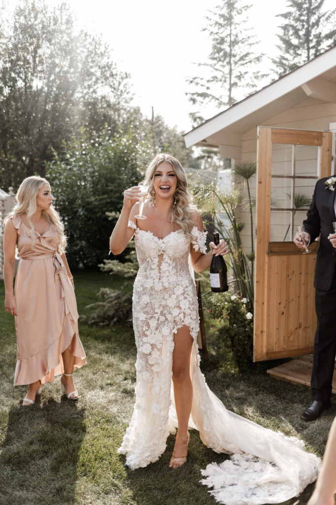 The bride celebrates with a champagne glass at this lakeside wedding at Alberta Beach