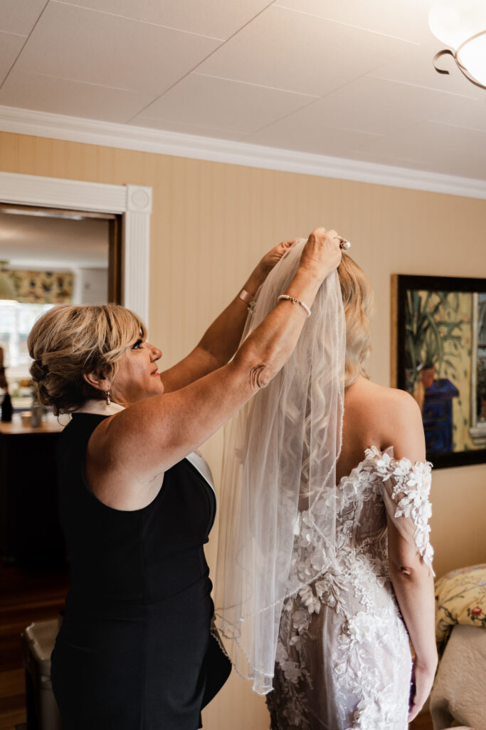 Bride's mother putting the veil on the bride at this lakeside wedding at Alberta Beach