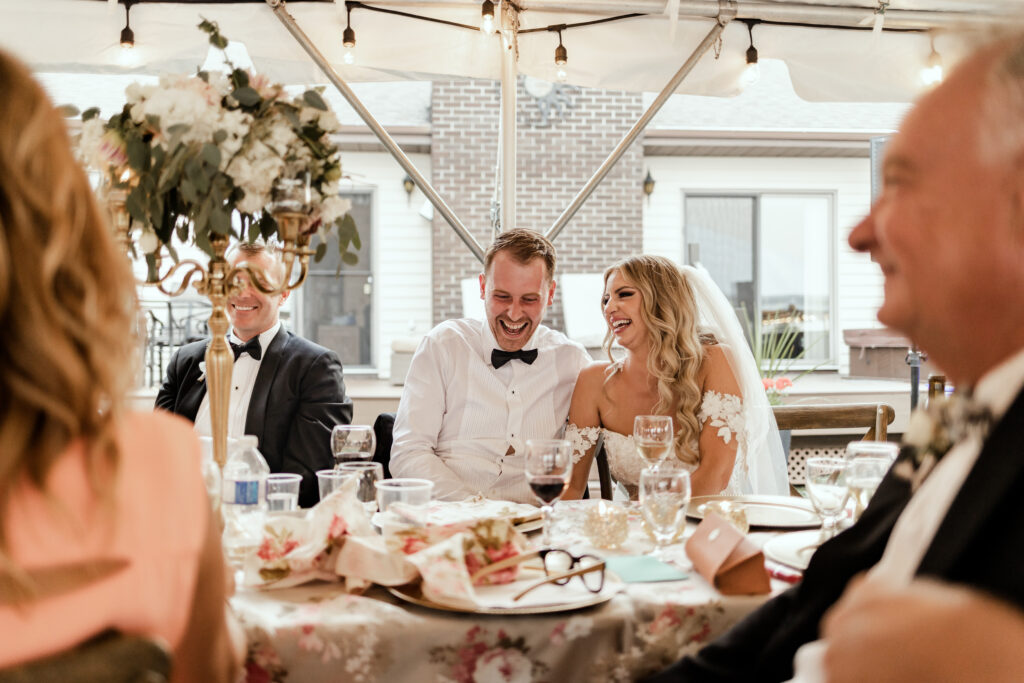 The couple share a laugh during speeches at this lakeside wedding at Alberta Beach